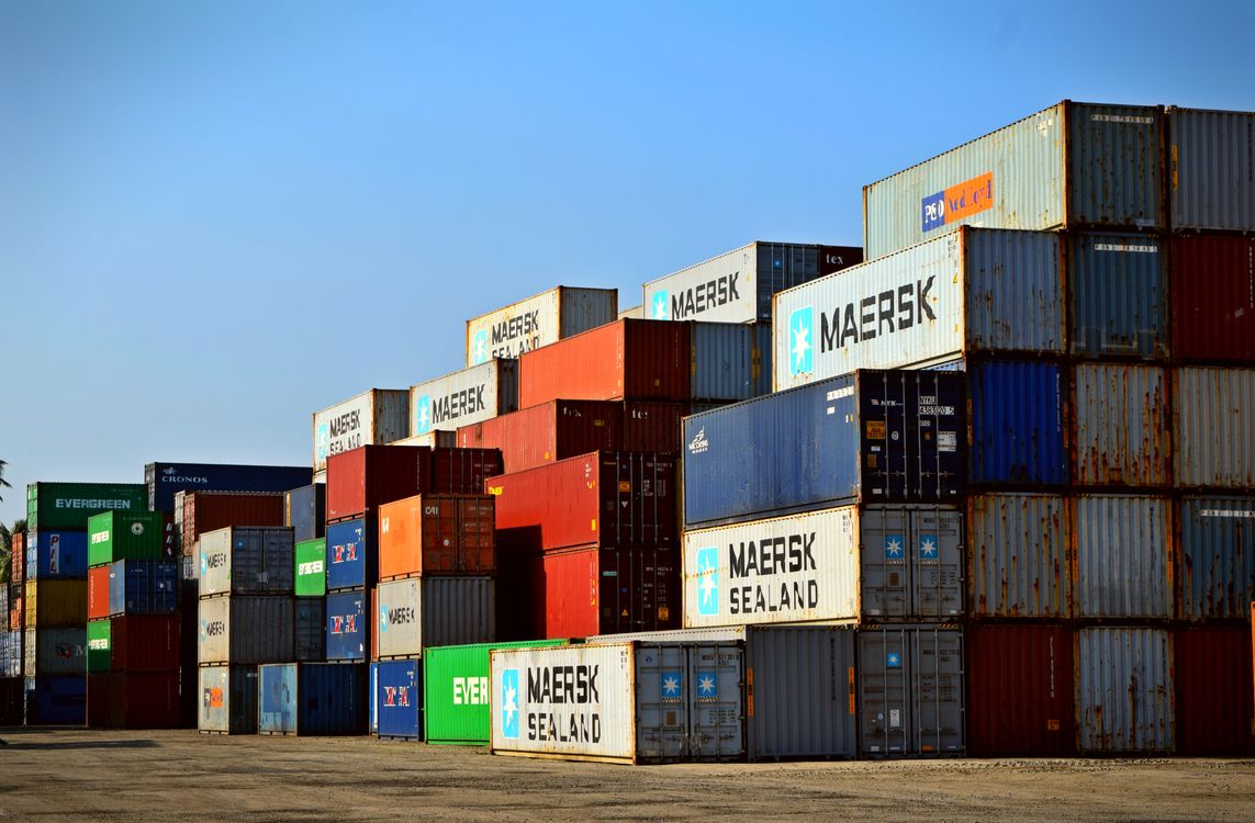 Colorful shipping containers stacked at a cargo port under blue sky, representing international freight logistics in Ghana