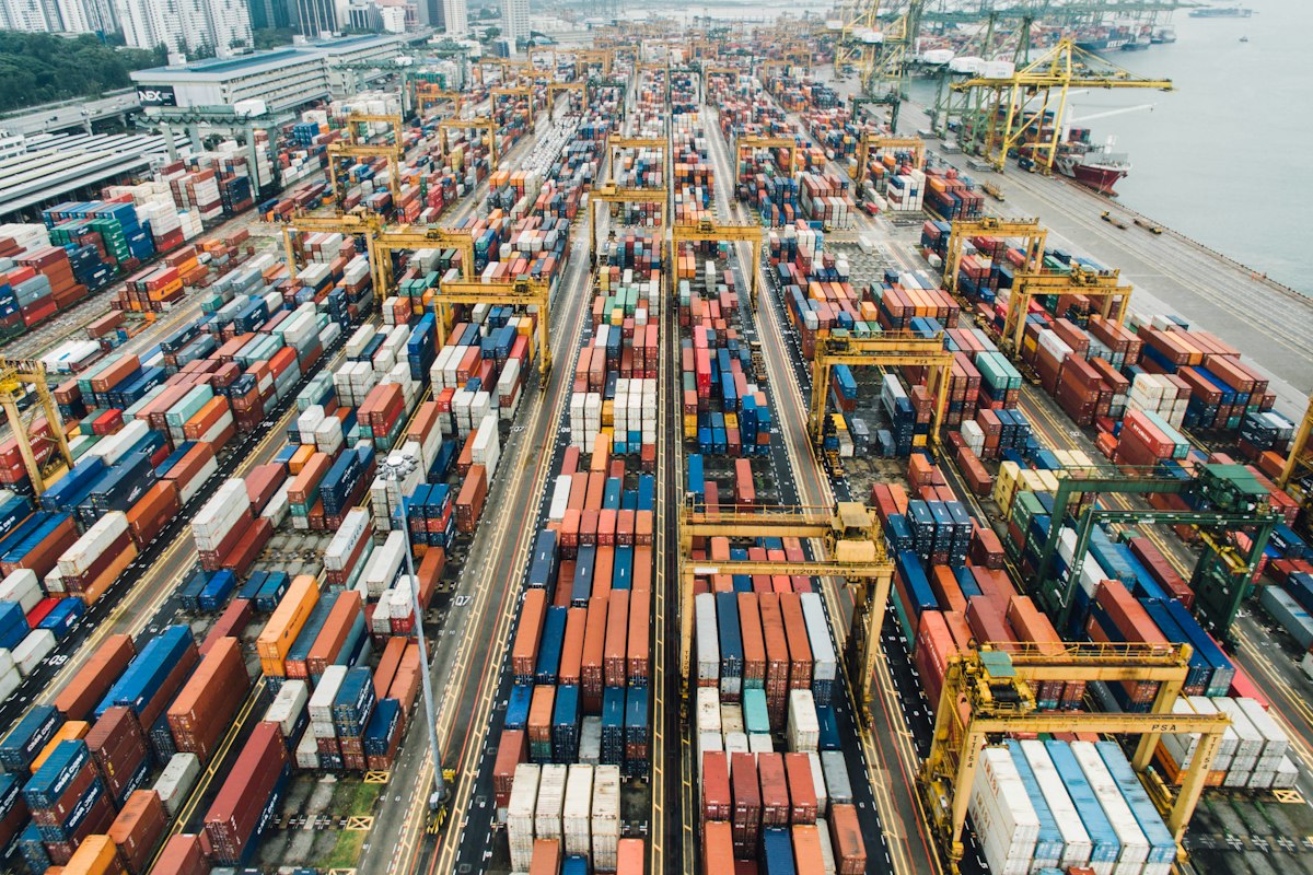 Shipping containers lined up at a busy commercial port ready for export