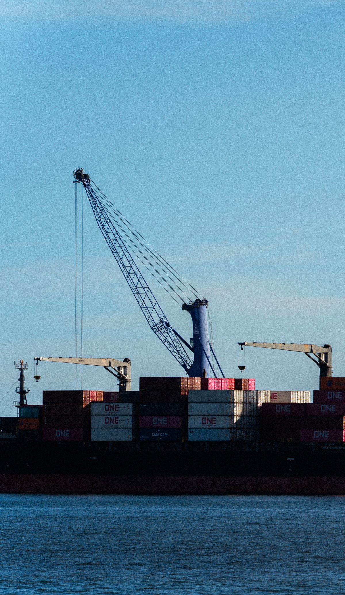 Industrial shipping port with stacked cargo containers and cranes